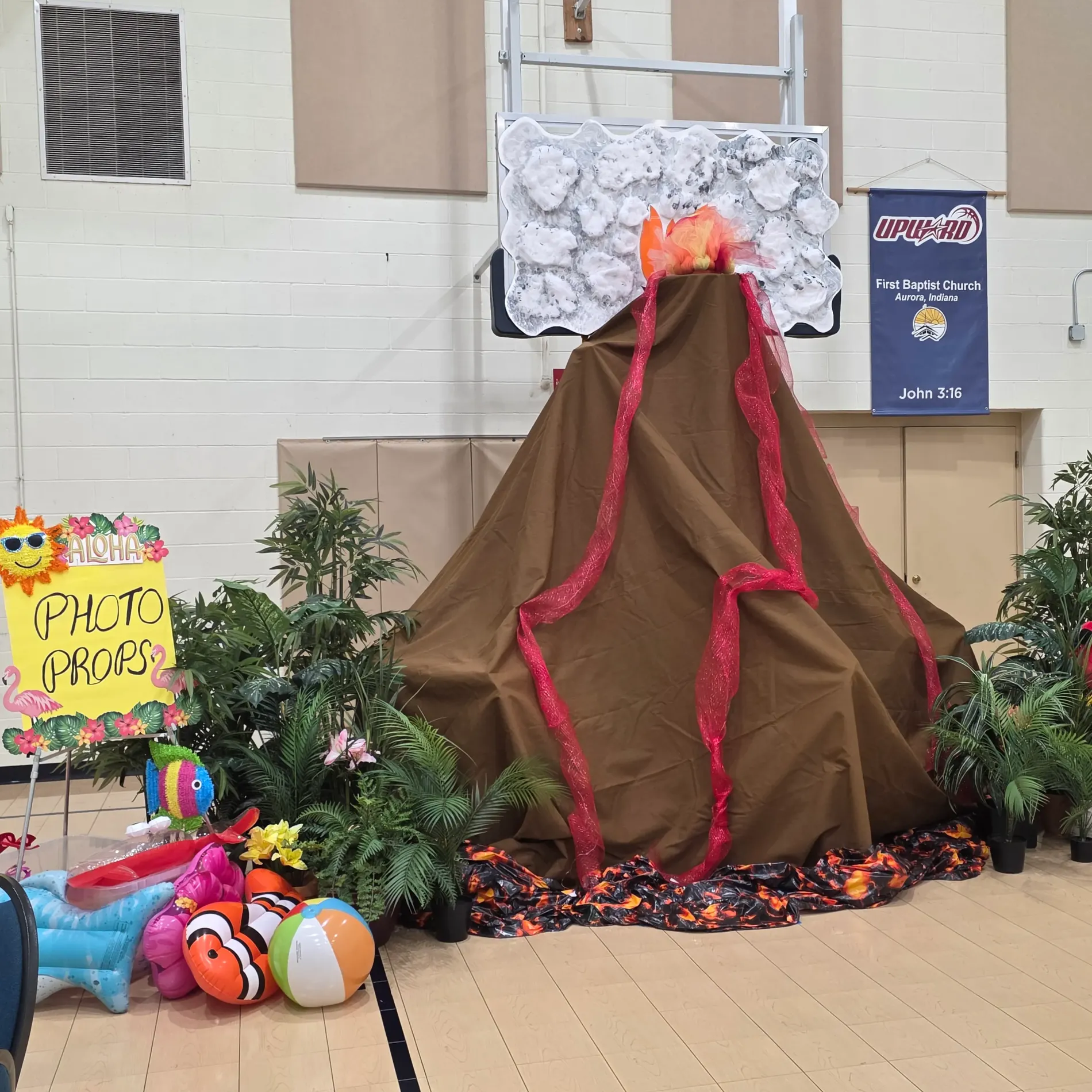 Volcano decoration with toys and tropical plants in a gym.