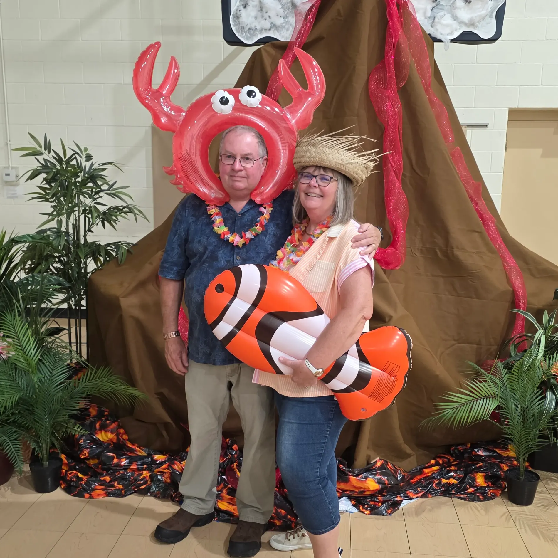 Couple in tropical costumes with inflatable crab and clownfish.