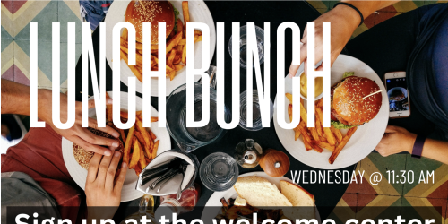 Diners gathered around a table with burgers and fries, viewed from above.